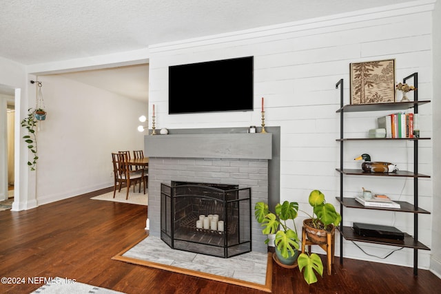 living room featuring hardwood / wood-style floors, a fireplace, and a textured ceiling