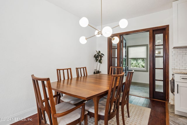 dining room with dark hardwood / wood-style flooring and a notable chandelier