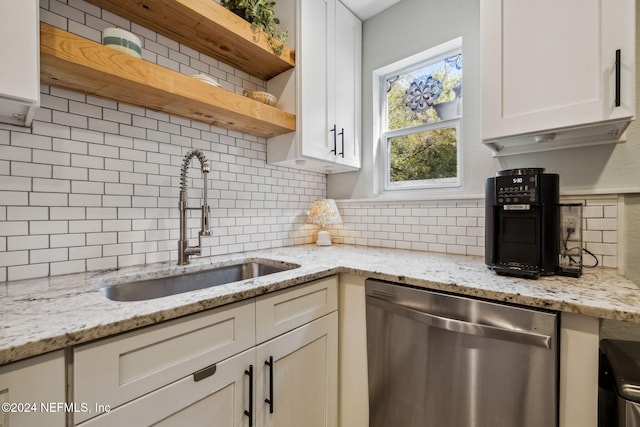 kitchen with dishwasher, backsplash, light stone counters, and sink