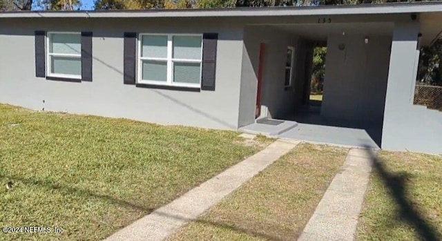 view of front of house with a front yard and a carport