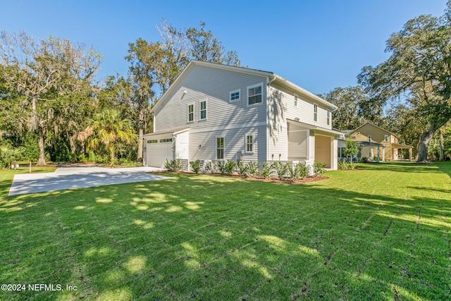 back of property featuring a garage and a yard