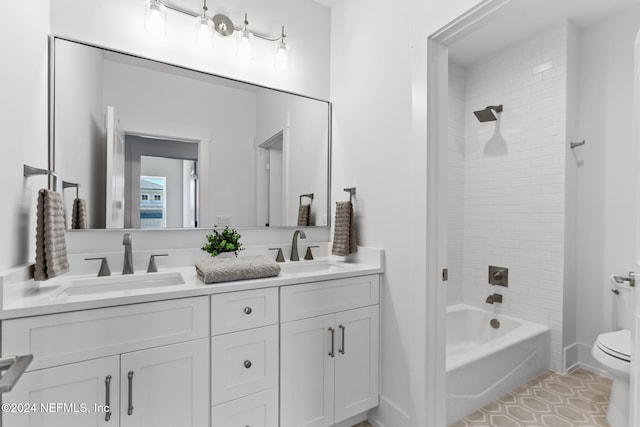 full bathroom featuring tile patterned flooring, vanity, tiled shower / bath combo, and toilet