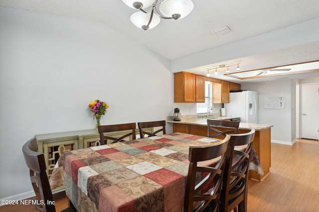 dining space featuring lofted ceiling and light hardwood / wood-style flooring