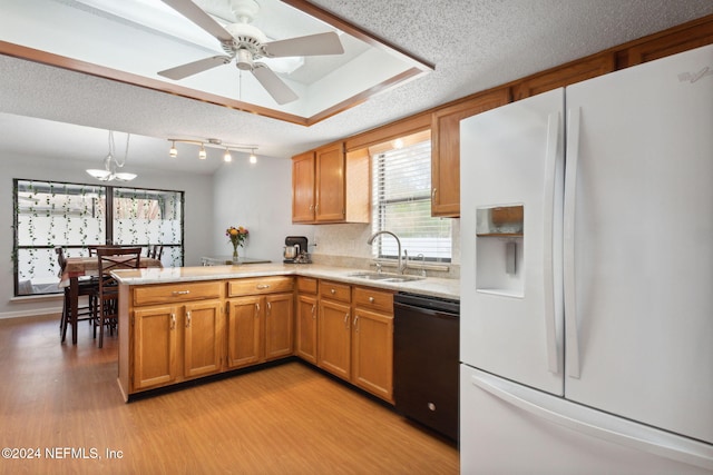 kitchen featuring dishwasher, white fridge with ice dispenser, sink, kitchen peninsula, and light hardwood / wood-style floors