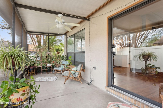 unfurnished sunroom with ceiling fan