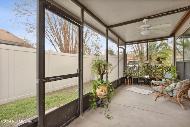 unfurnished sunroom with ceiling fan