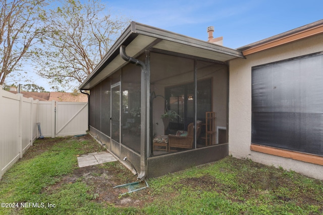 rear view of property featuring a sunroom