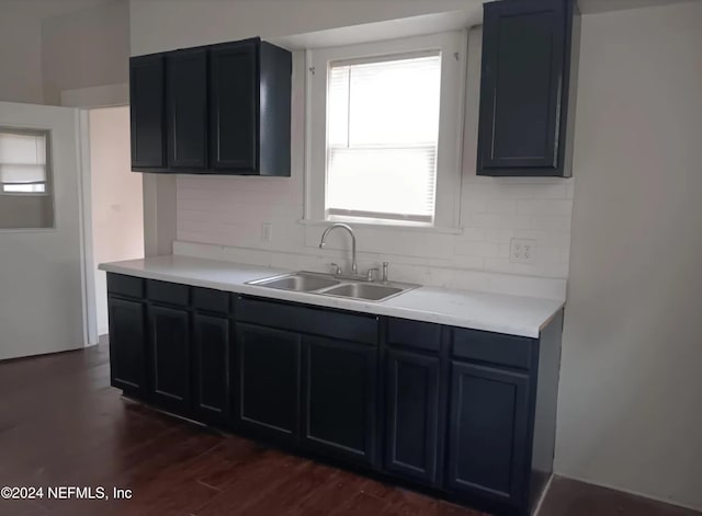 kitchen with dark hardwood / wood-style flooring, backsplash, and sink