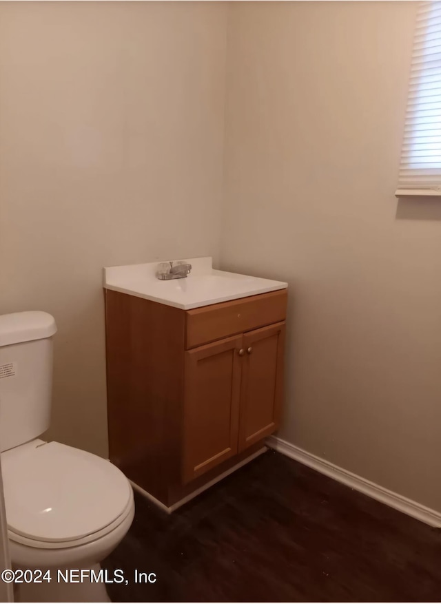 bathroom with hardwood / wood-style floors, vanity, and toilet