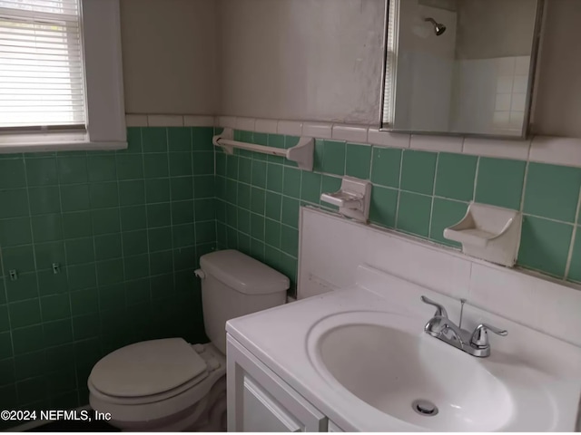 bathroom featuring vanity, toilet, and tile walls