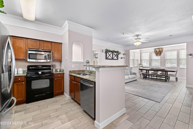 kitchen featuring sink, ceiling fan, appliances with stainless steel finishes, light stone counters, and kitchen peninsula