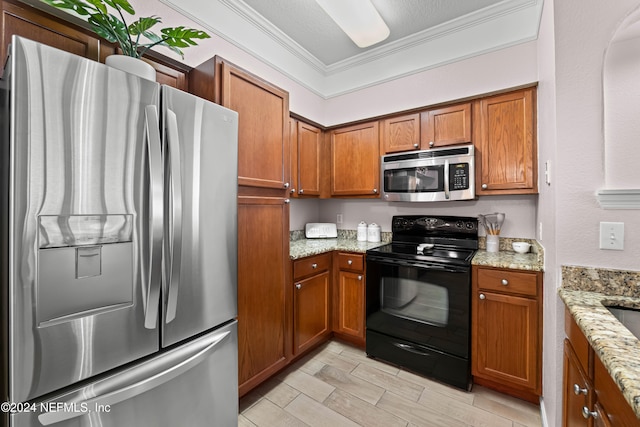 kitchen with appliances with stainless steel finishes, light wood-type flooring, light stone counters, a textured ceiling, and crown molding