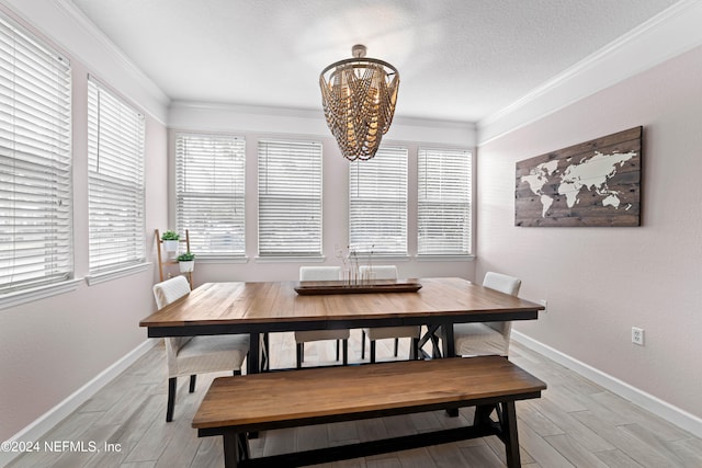 dining area featuring a chandelier, ornamental molding, light hardwood / wood-style flooring, and a healthy amount of sunlight