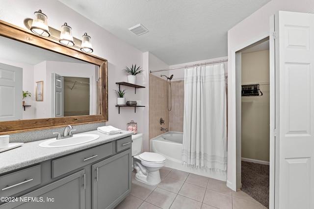 full bathroom with tile patterned flooring, vanity, a textured ceiling, and shower / tub combo