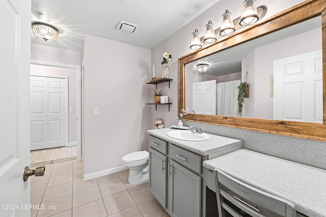 bathroom featuring tile patterned flooring, vanity, and toilet