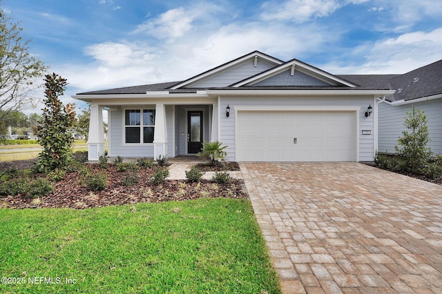 ranch-style house with a garage, covered porch, a front lawn, and decorative driveway