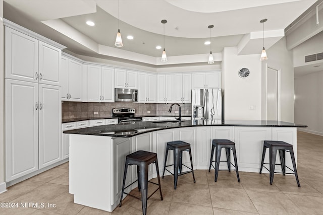 kitchen featuring white cabinets, a large island, stainless steel appliances, and a breakfast bar