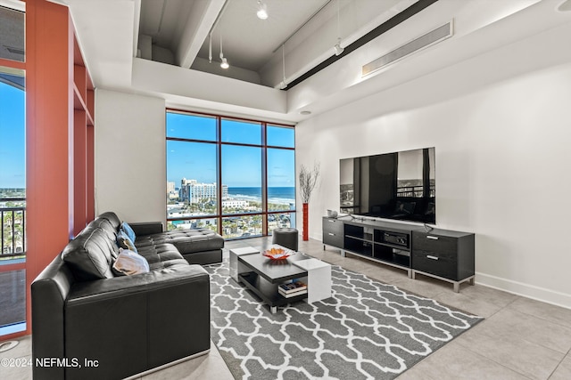 living room featuring beamed ceiling, a towering ceiling, and tile patterned floors