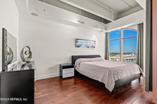 bedroom with dark wood-type flooring and a high ceiling