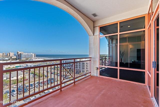 balcony with a water view and a beach view