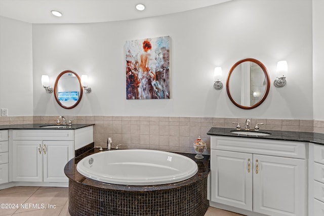 bathroom featuring tile patterned floors, vanity, and tiled bath