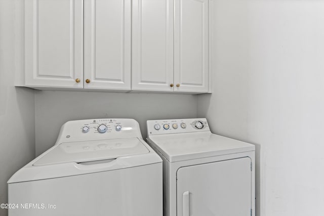 laundry room with cabinets and washing machine and clothes dryer