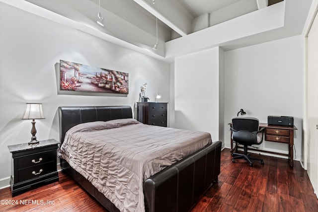 bedroom with a high ceiling and dark hardwood / wood-style flooring