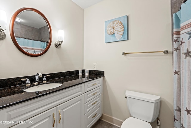 bathroom with tile patterned flooring, vanity, toilet, and walk in shower