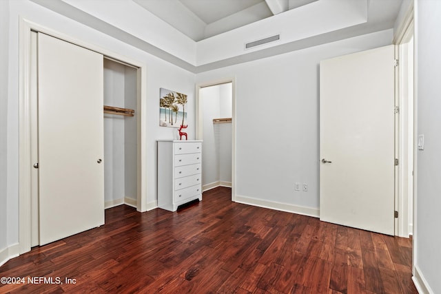 unfurnished bedroom with dark hardwood / wood-style flooring and a closet