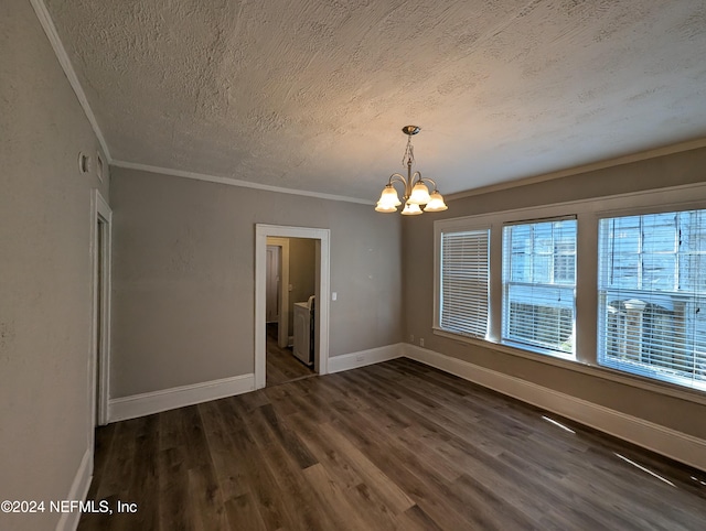 unfurnished dining area featuring dark hardwood / wood-style flooring, ornamental molding, a textured ceiling, and a chandelier