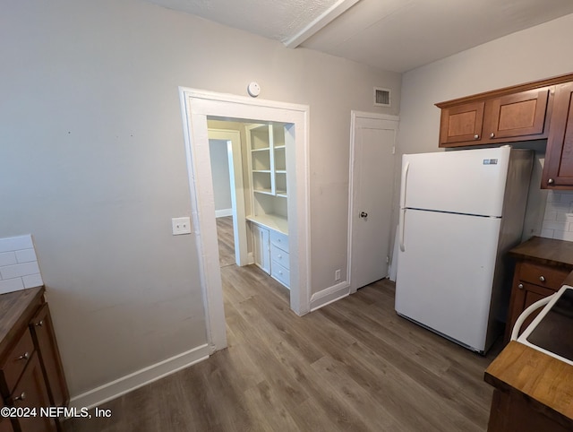 kitchen featuring backsplash, hardwood / wood-style floors, and white refrigerator