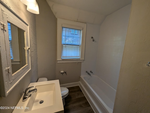 bathroom with hardwood / wood-style floors, toilet, lofted ceiling, and sink