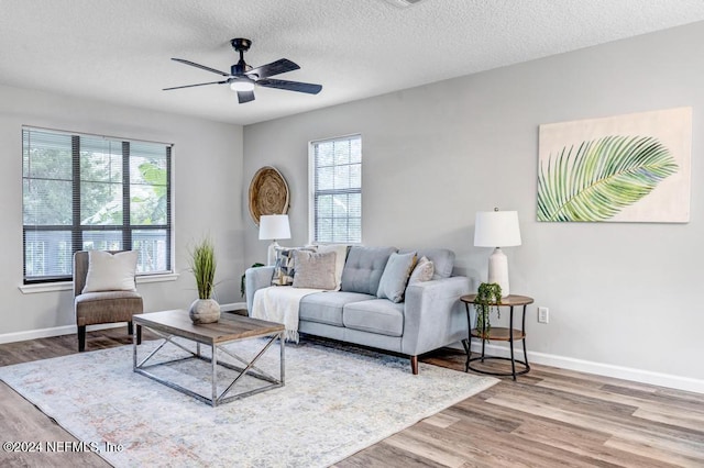 living room with ceiling fan, hardwood / wood-style flooring, and a textured ceiling