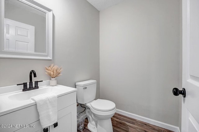 bathroom featuring hardwood / wood-style floors, vanity, a textured ceiling, and toilet