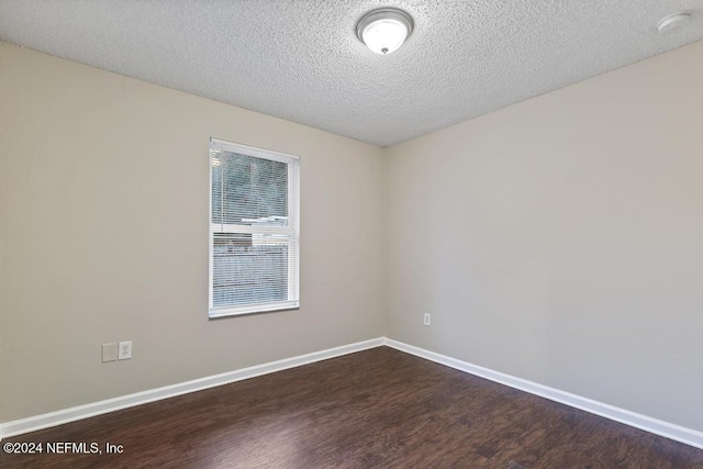 unfurnished room featuring a textured ceiling and dark hardwood / wood-style floors