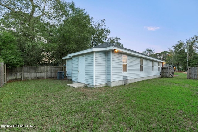 view of side of property featuring a yard and central AC unit