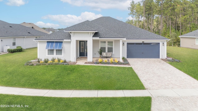 view of front of house featuring a porch, a garage, and a front yard