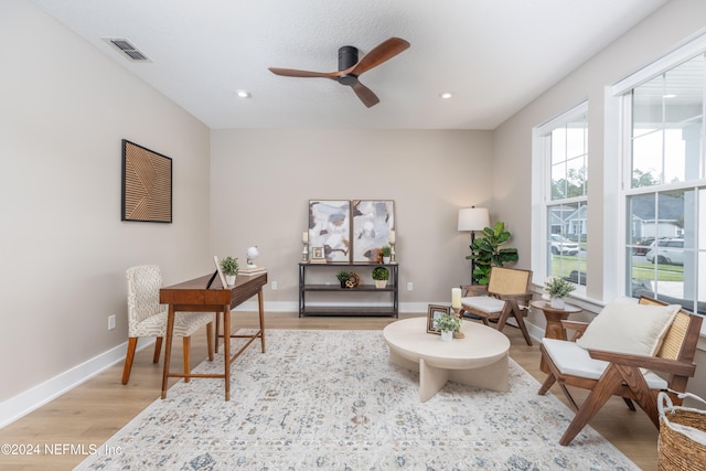 living area featuring light hardwood / wood-style flooring and ceiling fan