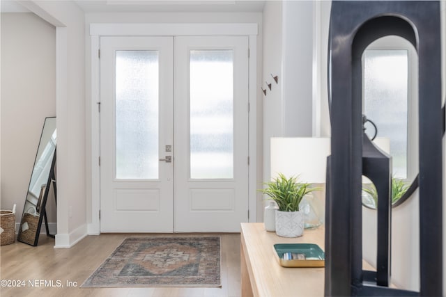 foyer featuring french doors, light hardwood / wood-style flooring, and a healthy amount of sunlight