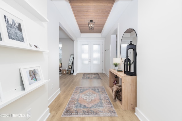 foyer with french doors, wood ceiling, and light hardwood / wood-style flooring