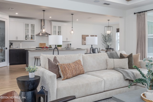 living room featuring a chandelier and light hardwood / wood-style flooring