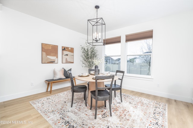 dining area with hardwood / wood-style floors and an inviting chandelier