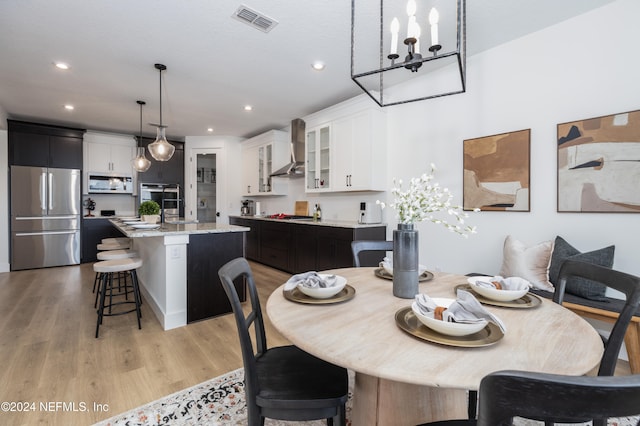 dining area with light hardwood / wood-style flooring and a notable chandelier