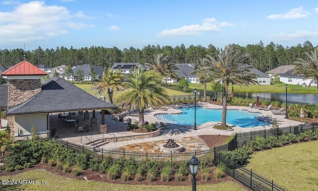 view of swimming pool featuring a water view and a patio