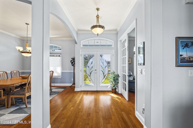 entryway with french doors, crown molding, and hardwood / wood-style floors