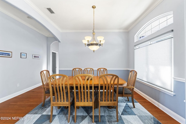 dining area with dark hardwood / wood-style flooring, a chandelier, and ornamental molding