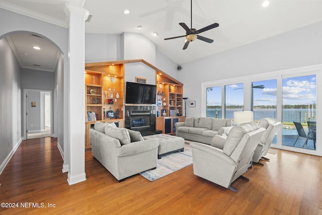 living room with ornate columns, ornamental molding, ceiling fan, hardwood / wood-style flooring, and high vaulted ceiling