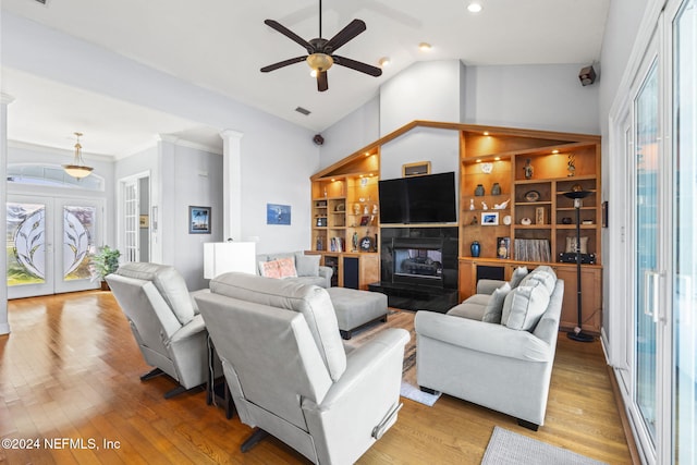 living room with vaulted ceiling, light hardwood / wood-style flooring, a wealth of natural light, and french doors