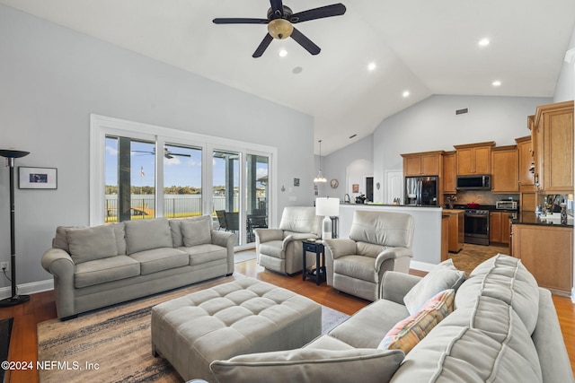 living room with ceiling fan, high vaulted ceiling, and light hardwood / wood-style floors