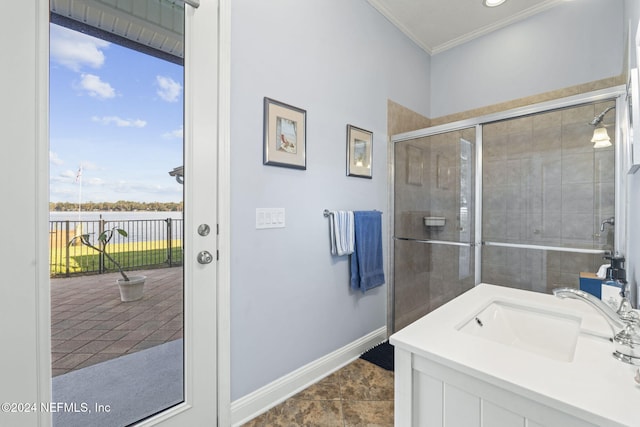 bathroom featuring tile patterned floors, vanity, a shower with shower door, and crown molding